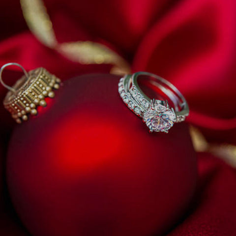 Diamond engagement ring on a red ball christmas ornament